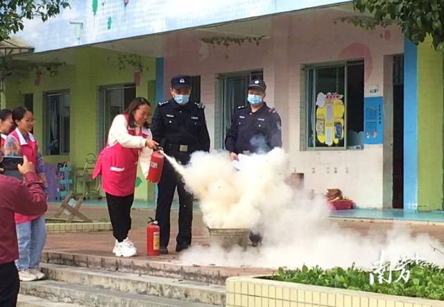 公安民警變身“消防安全老師”，指導(dǎo)幼兒園老師使用滅火器。